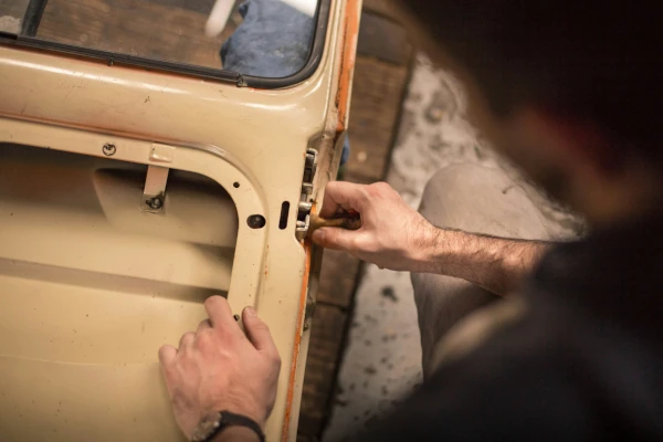 a bodyshop repair technician fixing a car door